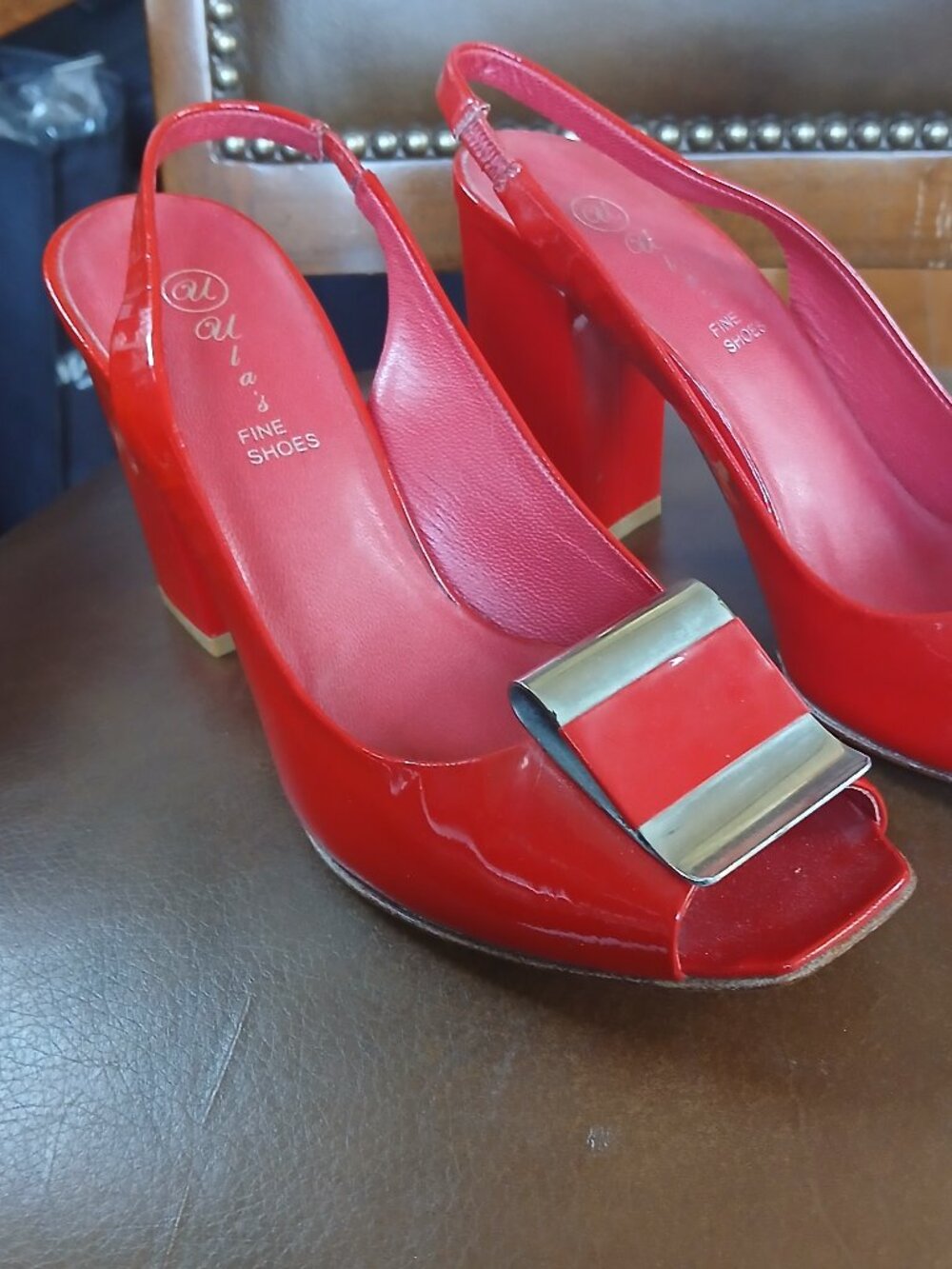 Pair of patent leather pumps in a fashionable red color.